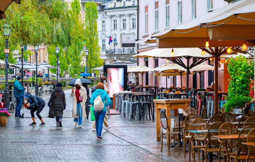 Ljudje v središču Ljubljane v vsakdanjem delovnem ritmu, simbol sprememb na trgu dela v Sloveniji
